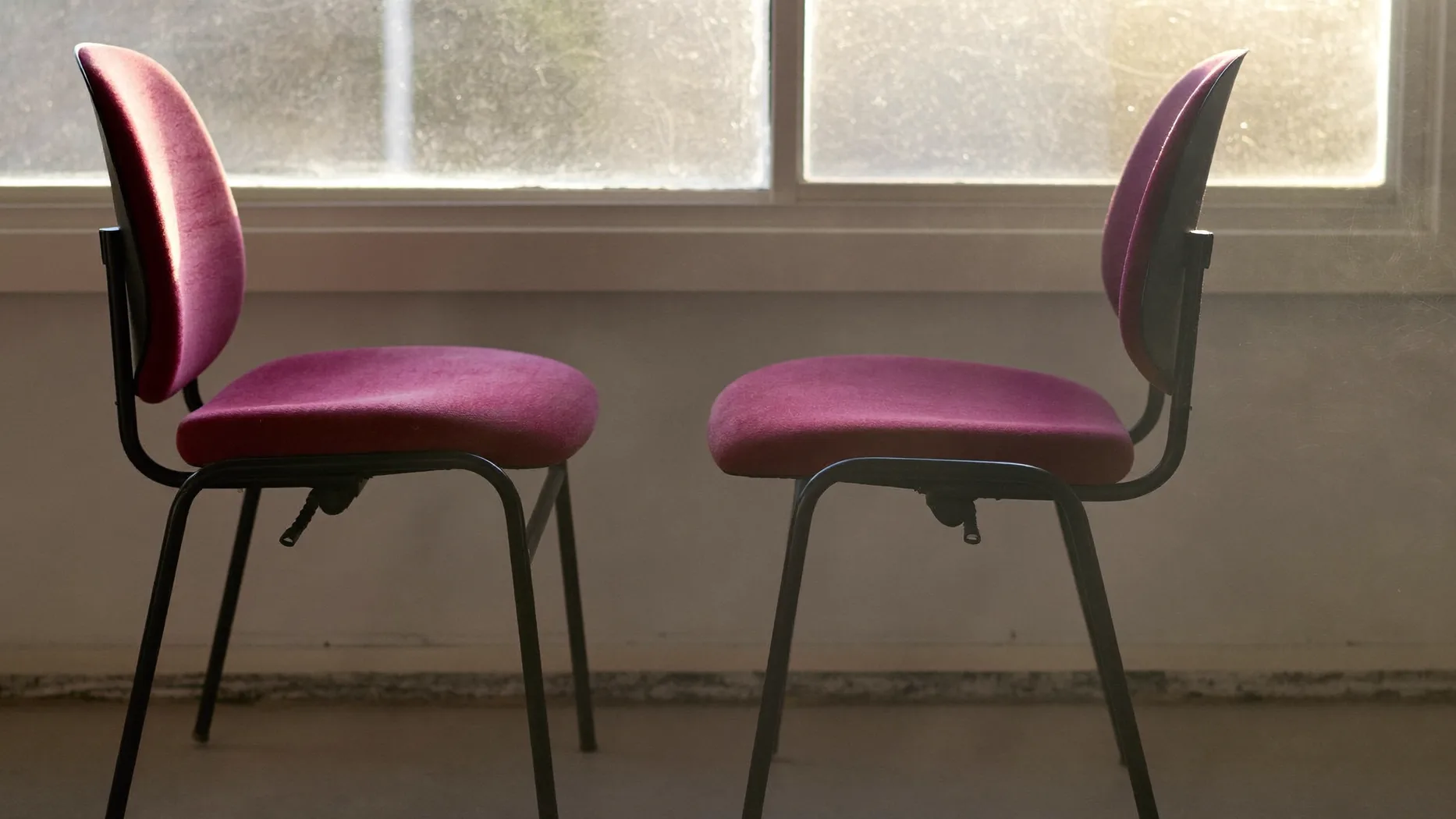 Due sedie da ufficio una di fronte all'altra davanti a una finestra